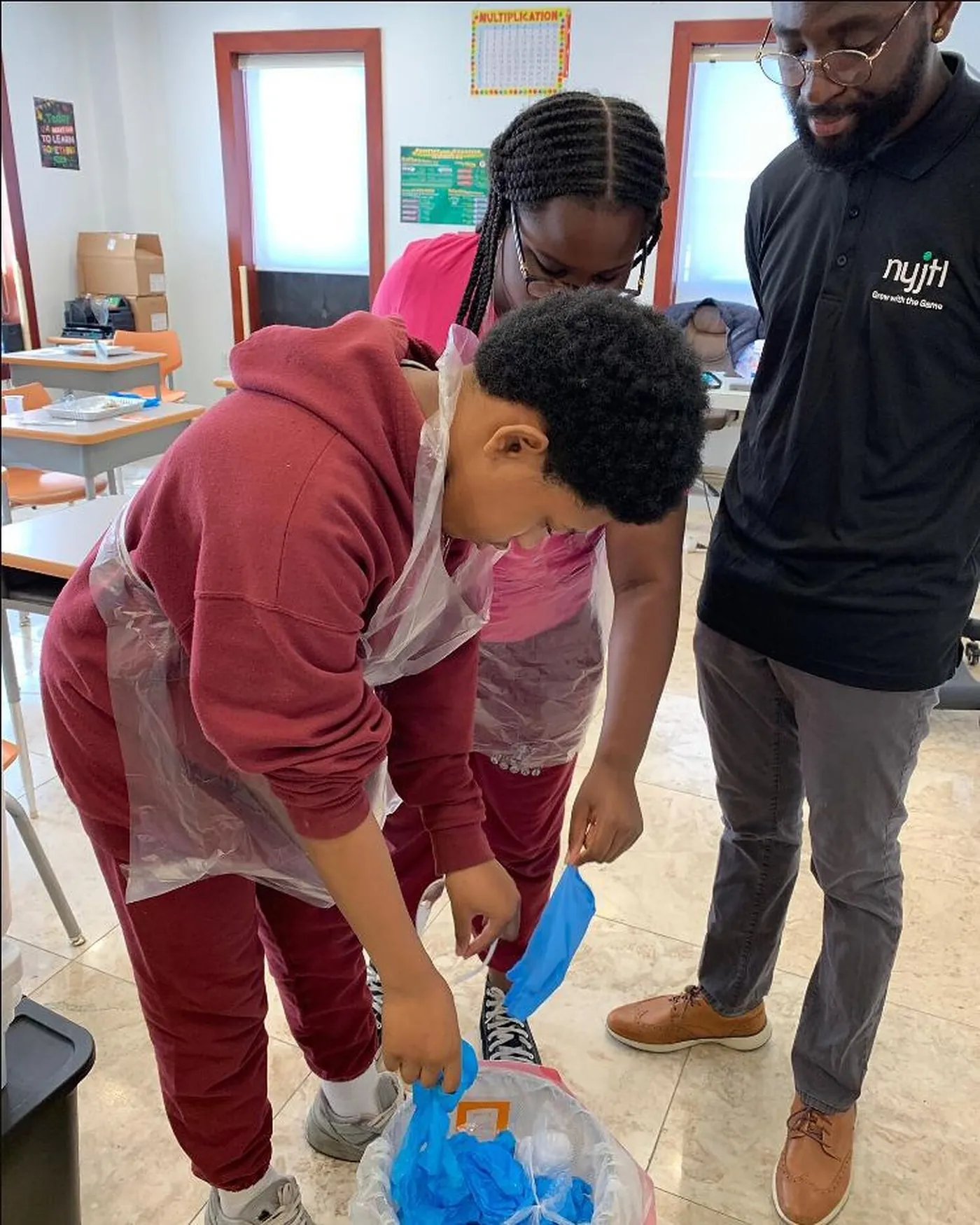 Students and a teacher running an experiment together